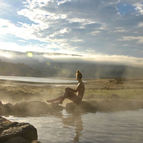 A bather enjoys the sunrise at the thermal springs