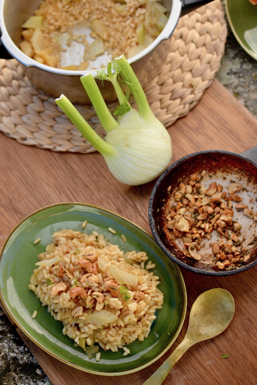 The finished dish served on a plate, next to a small pan of cashews