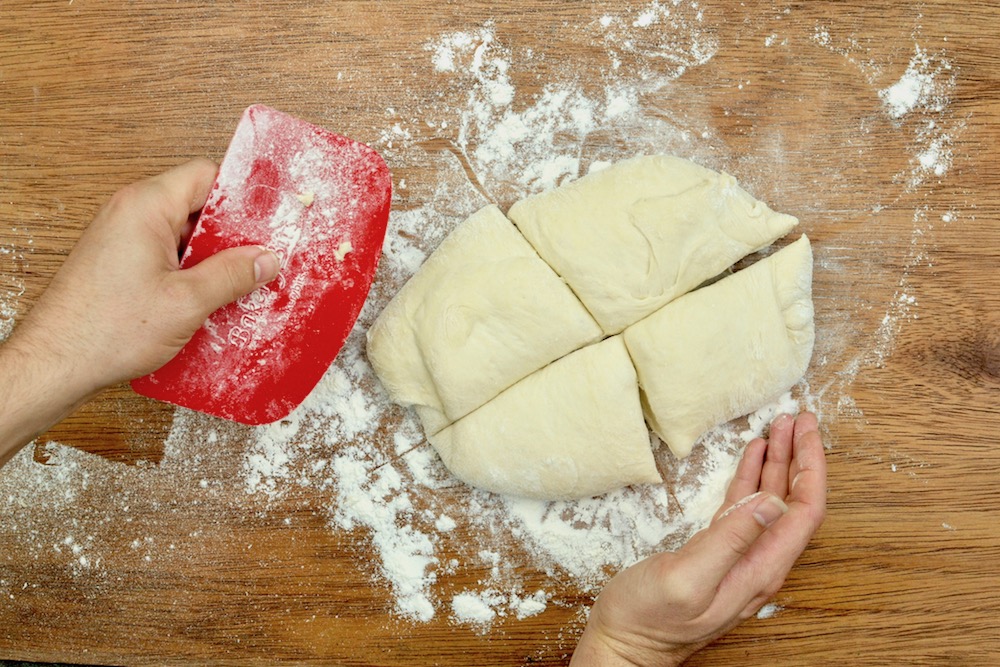 Cutting the pizza dough into four pieces