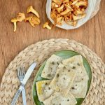 A plate of homemade ravioli next to a bag of foraged chanterelle mushrooms