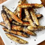 A white plate with finger shaped poppy seed covered potato noodles