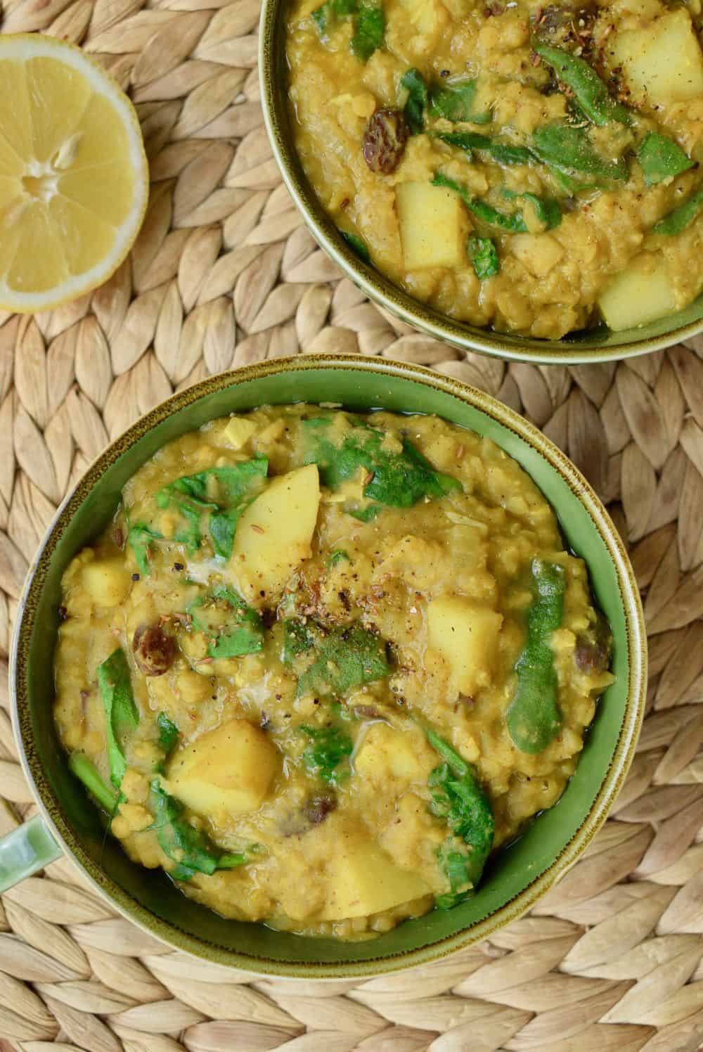 The fresh green colour of spinach stands out against the golden yellow lentil dahl