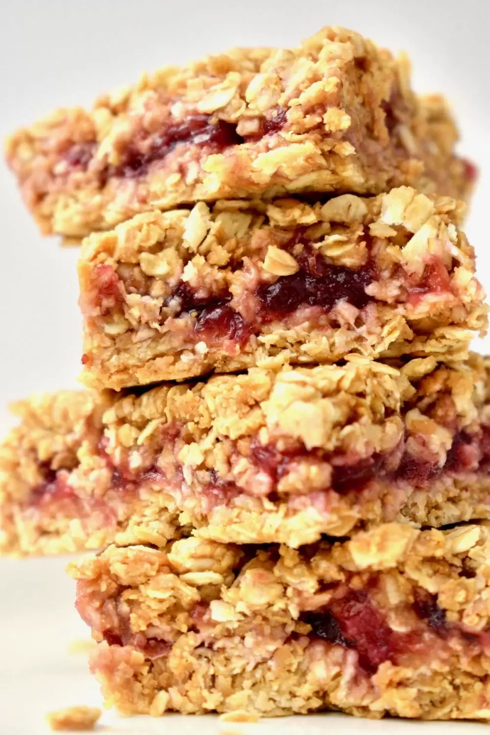 A stack of peanut butter oat bars, filled with jam
