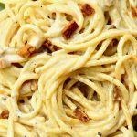 Spaghetti covered in a creamy vegan carbonara sauce, with smoked tofu pieces