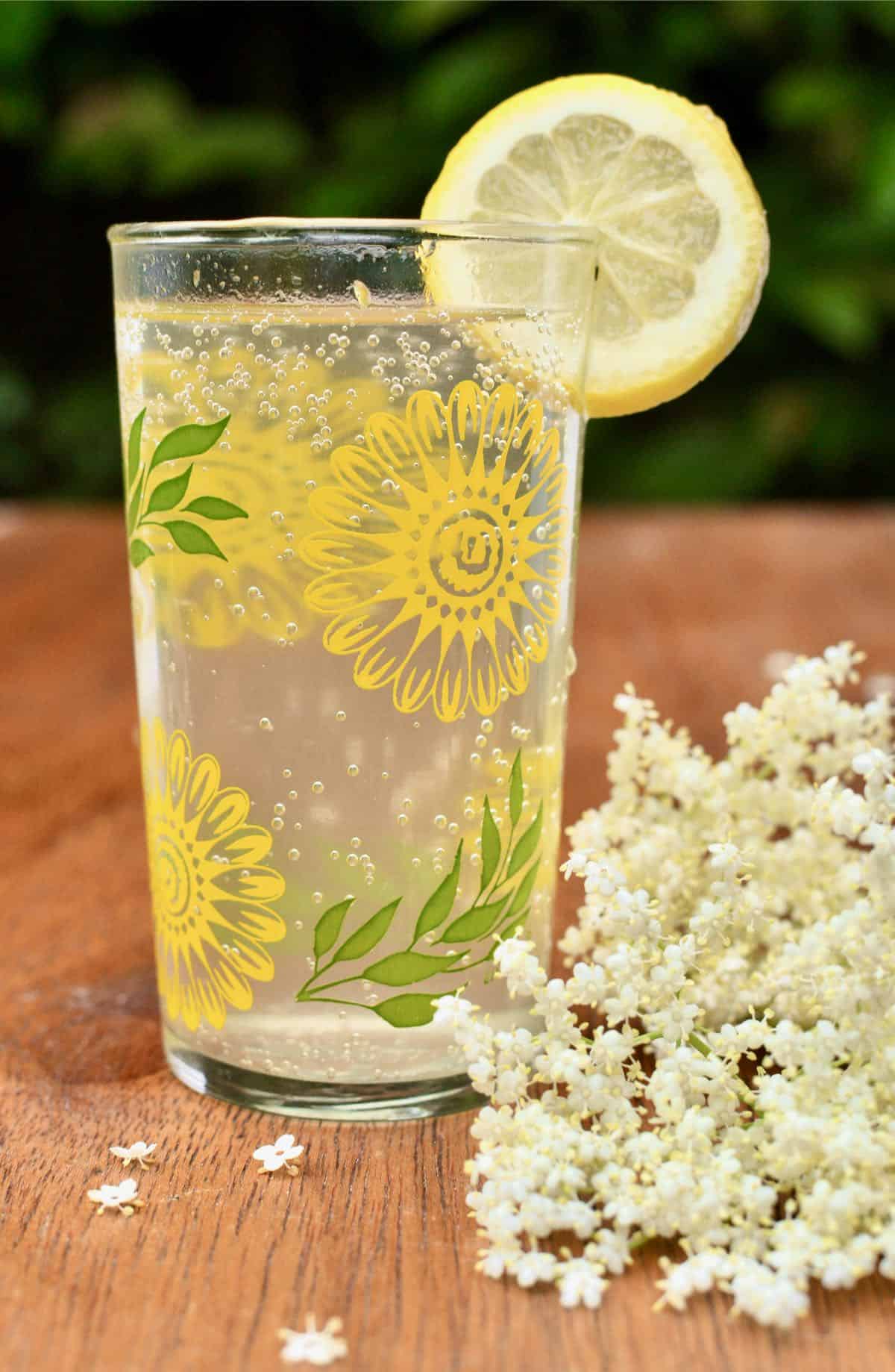 A glass of freshly made, diluted cordial garnished with a slice of lemon 