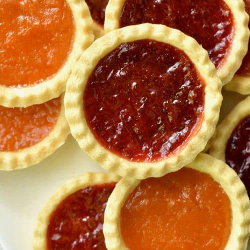 An assortment of jam tarts filled with red berry and apricot jam