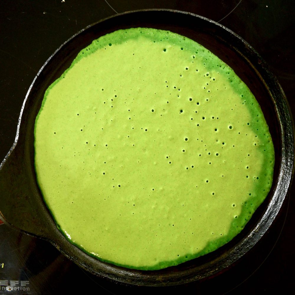 Pale green batter spread out in a pan