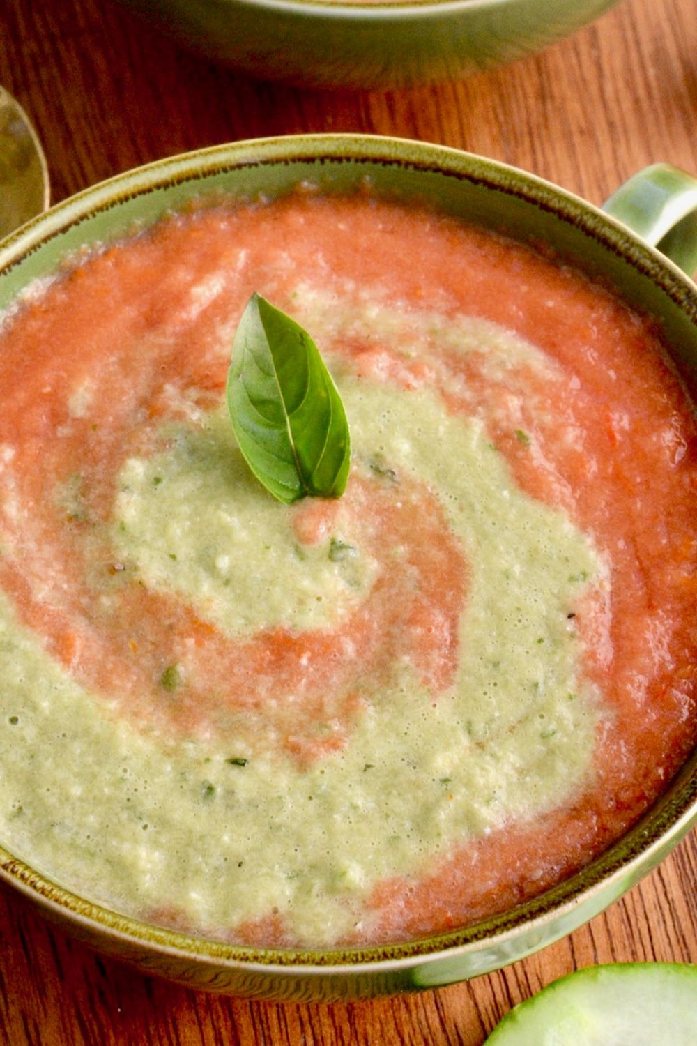 A basil leaf garnishes the gazpacho