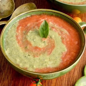 A green bowl with a red and green swirled gazpacho