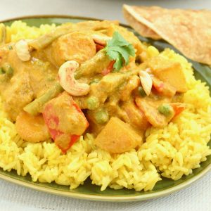 A serving of veggie korma on top of a pile of Indian spiced rice