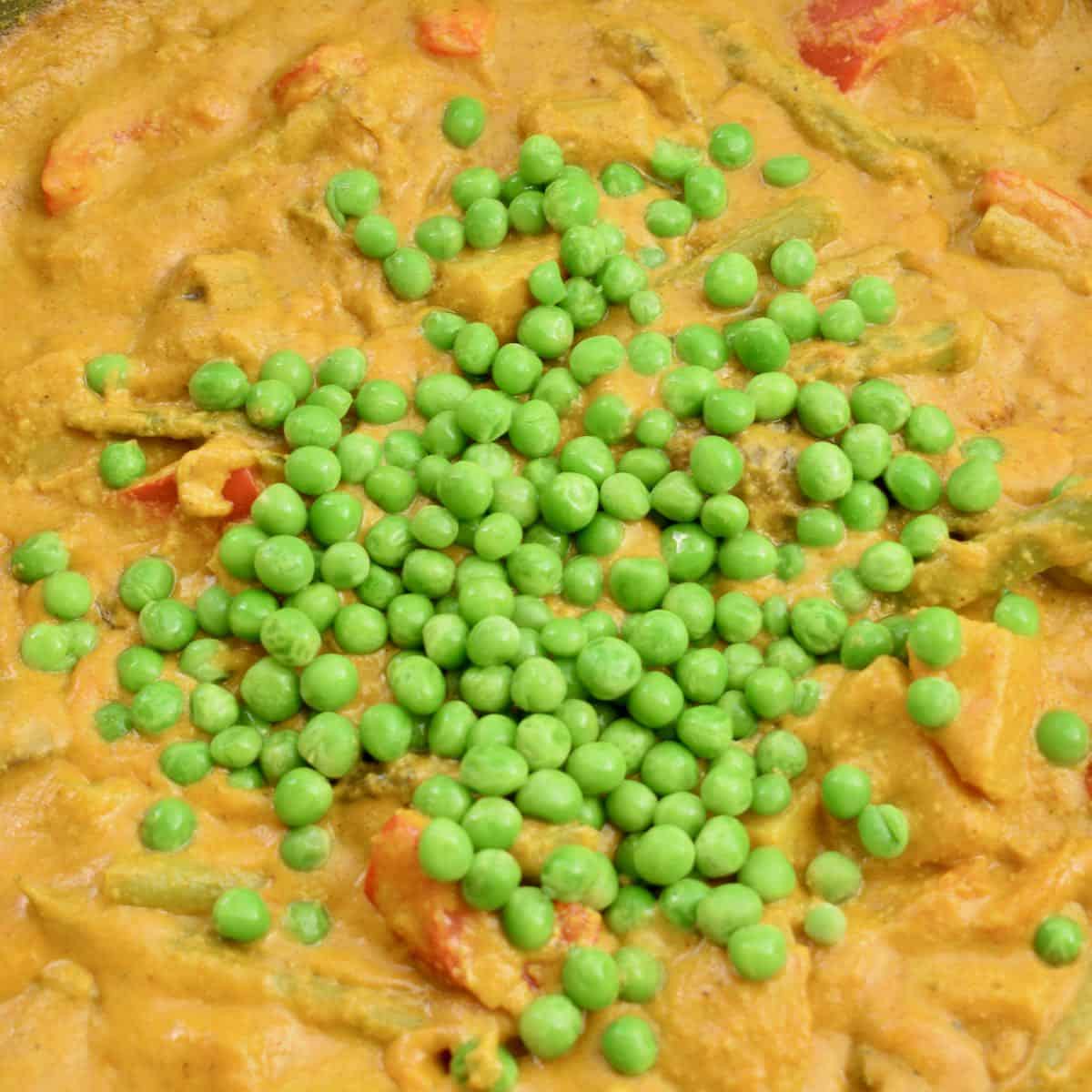 Adding the frozen peas to the almost finished dish.