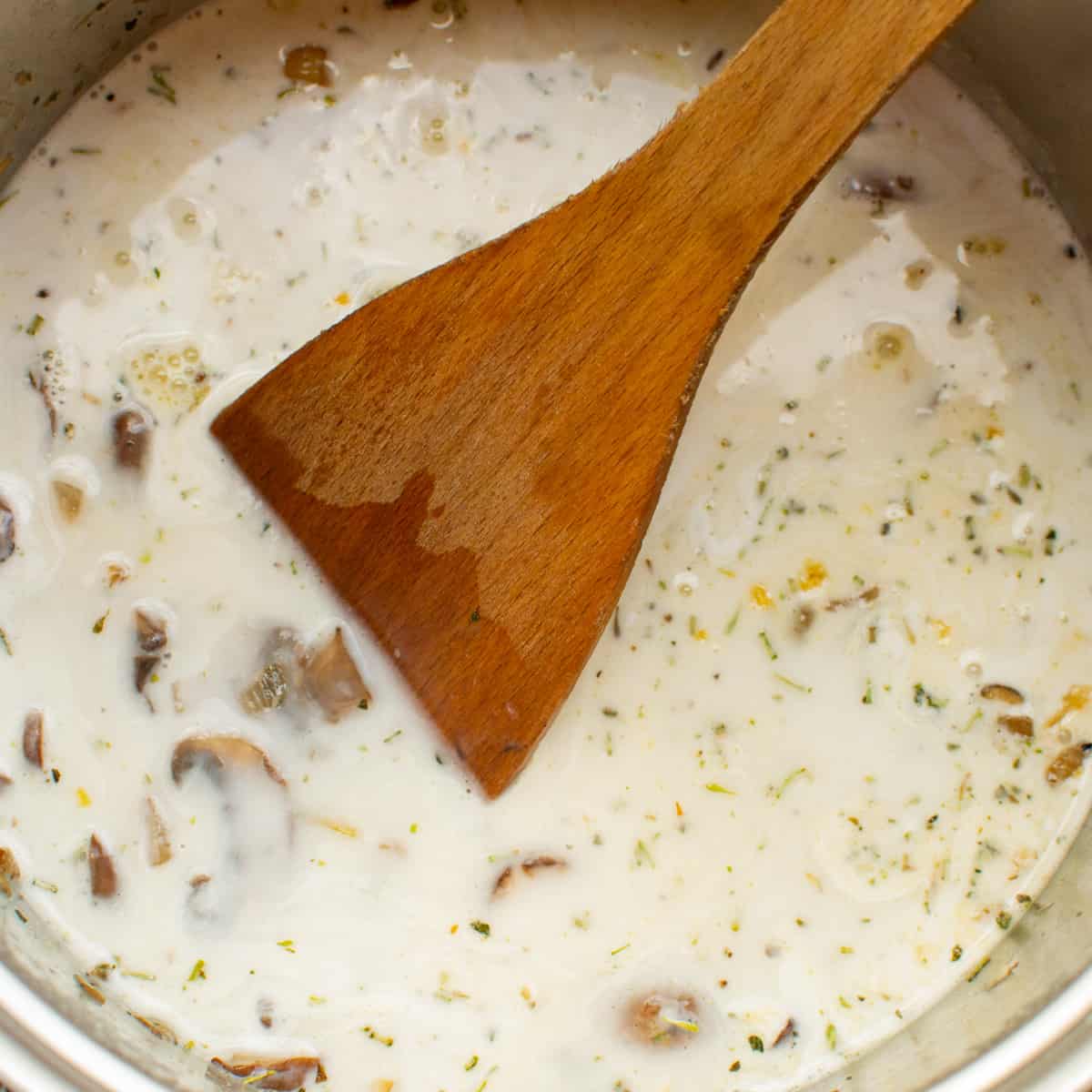 A wooden spatula stirs the soup.