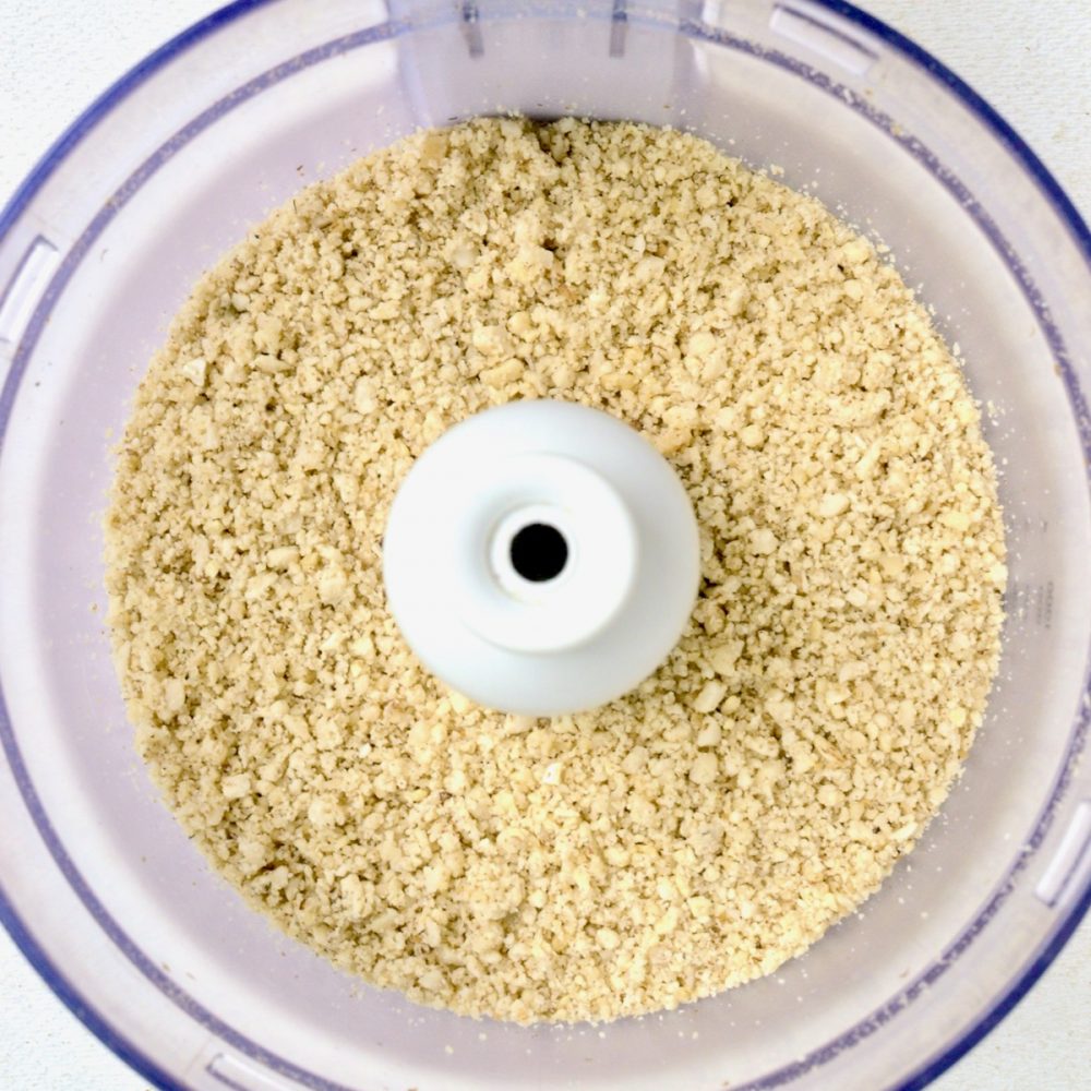 The mixed nuts have been ground to a slightly grainy texture in a food processor.