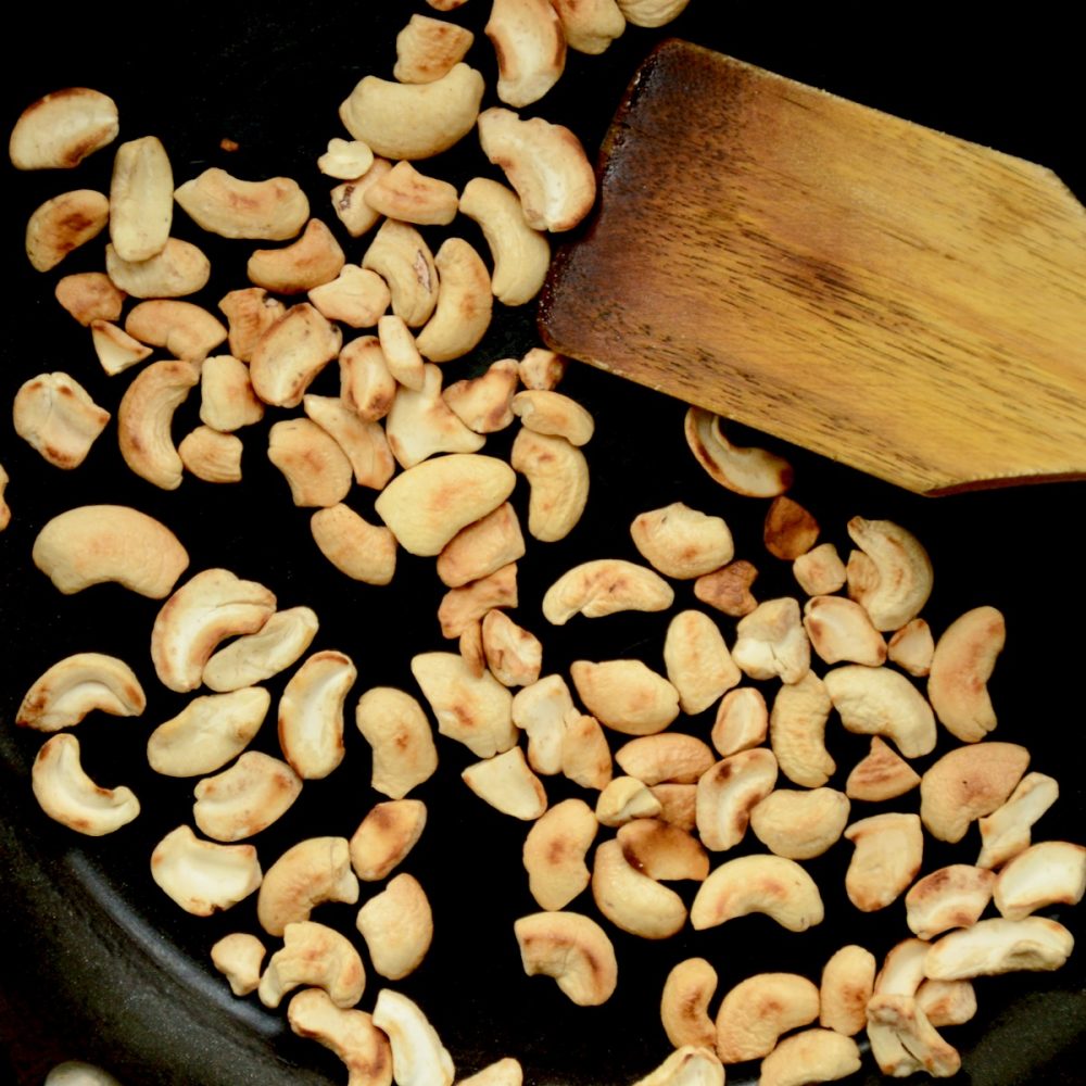 Toasting cashews in a pan.