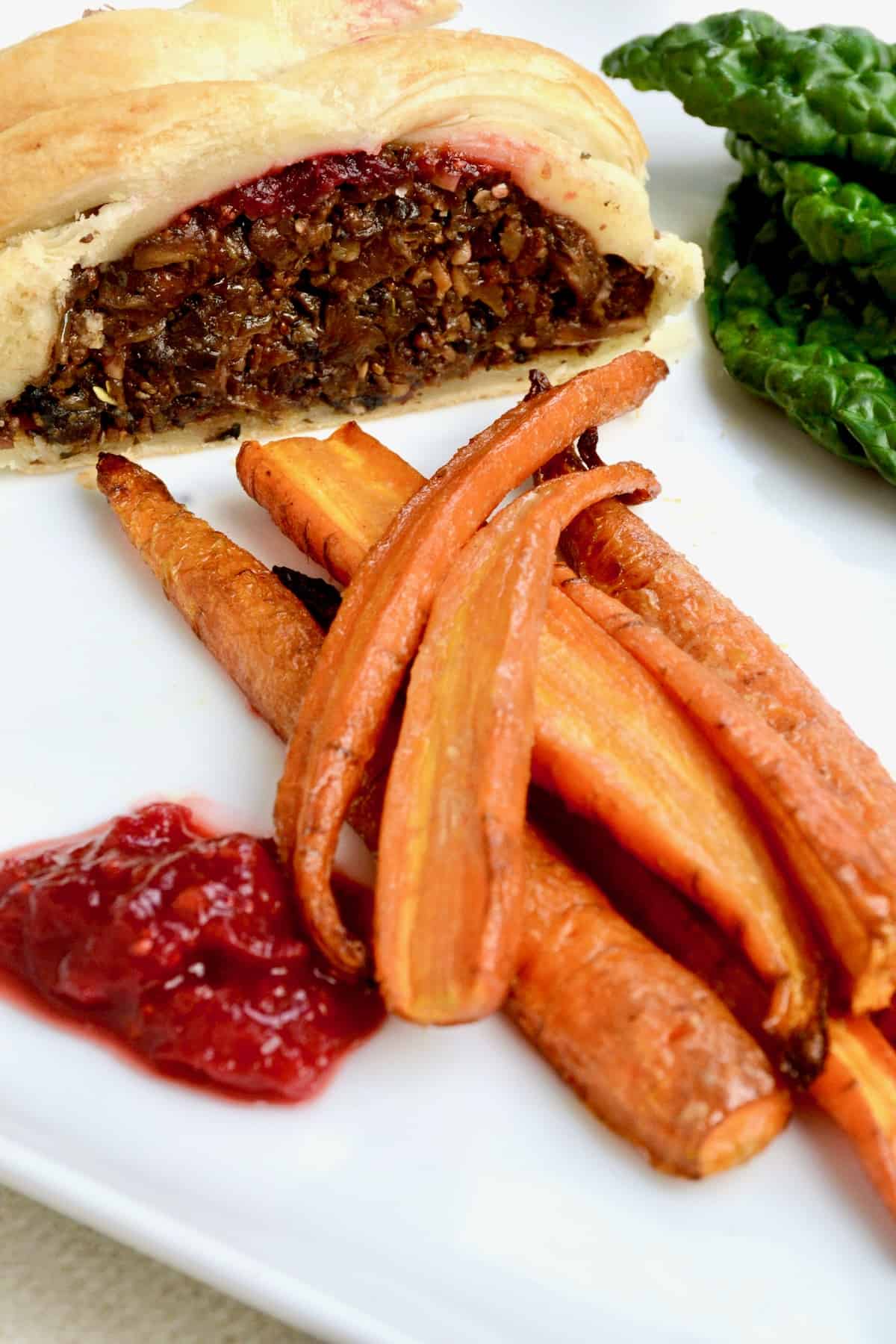 Roasted carrots with mustard maple syrup glaze served as a side dish to a vegan mushroom wellington.