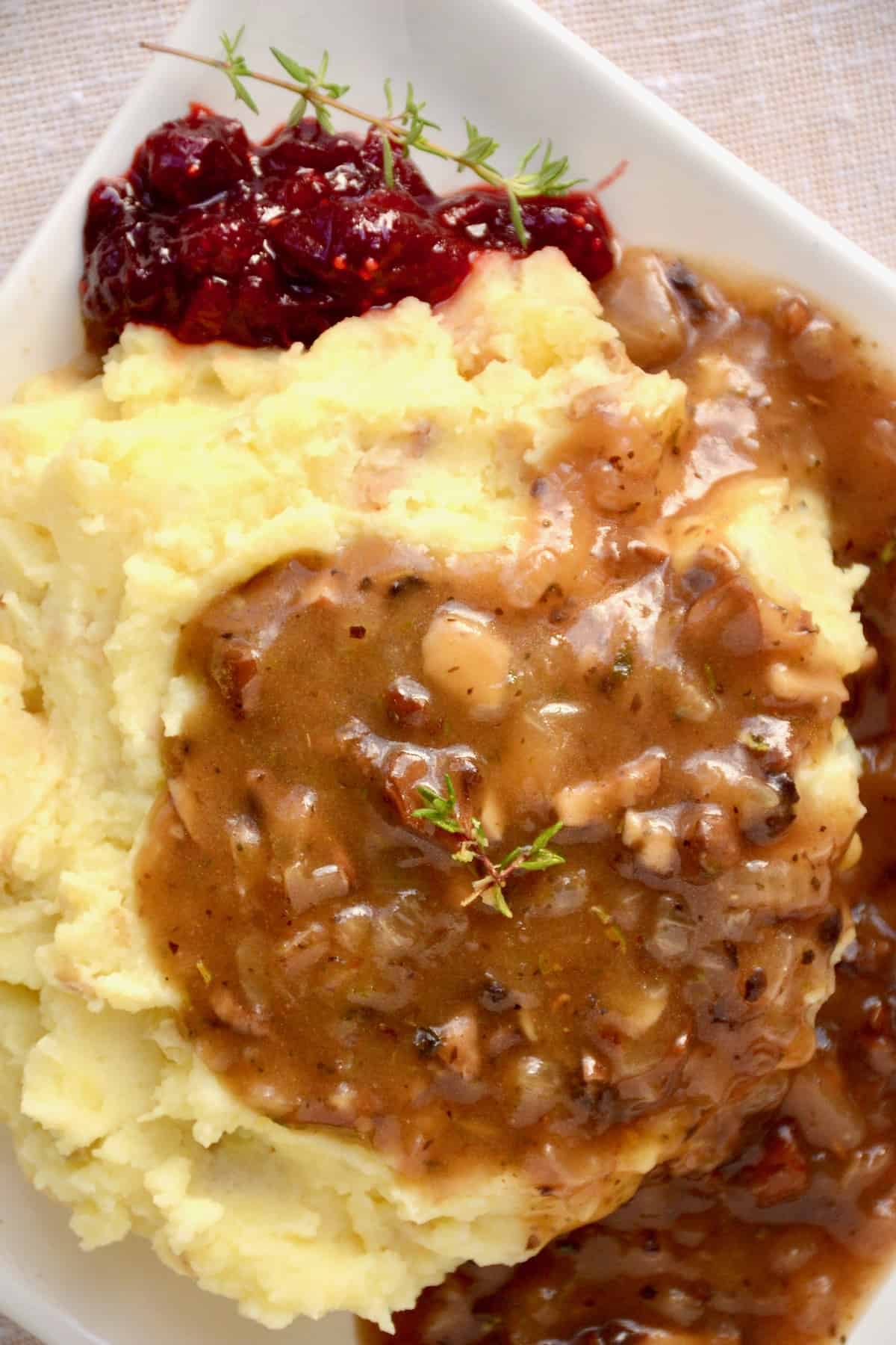 A plate of mashed potato with a generous serving of gravy.
