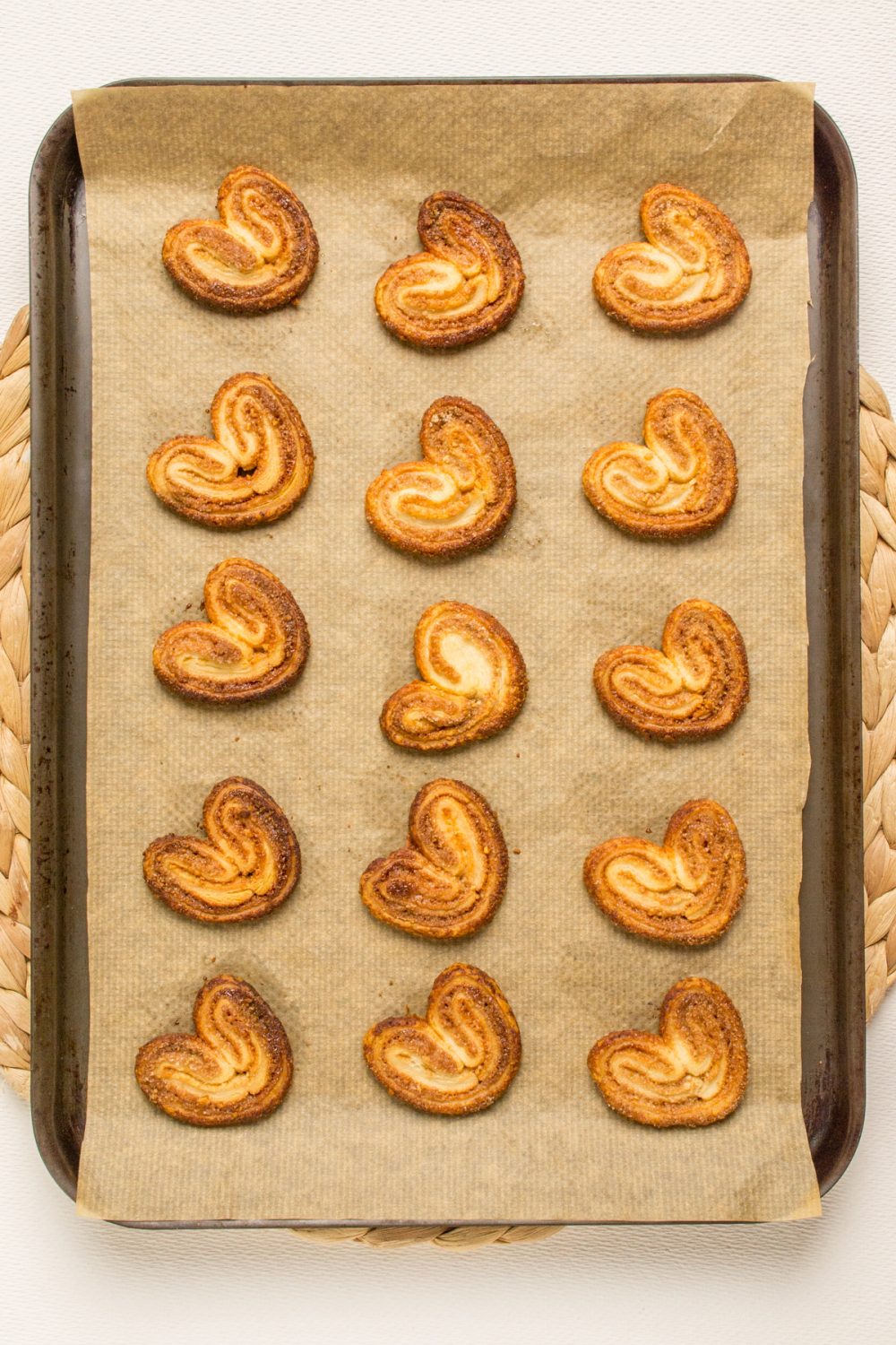 Fifteen baked cookies on a lined baking tray.