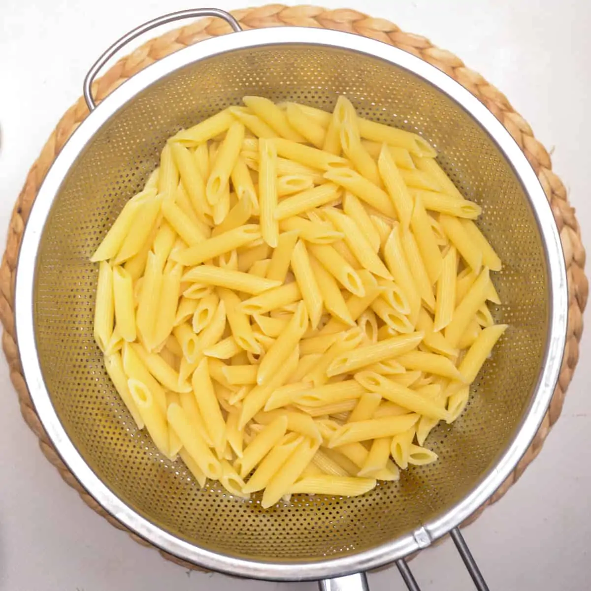 Drained cooked pasta in a sieve. Reserve of the drained cooking water.