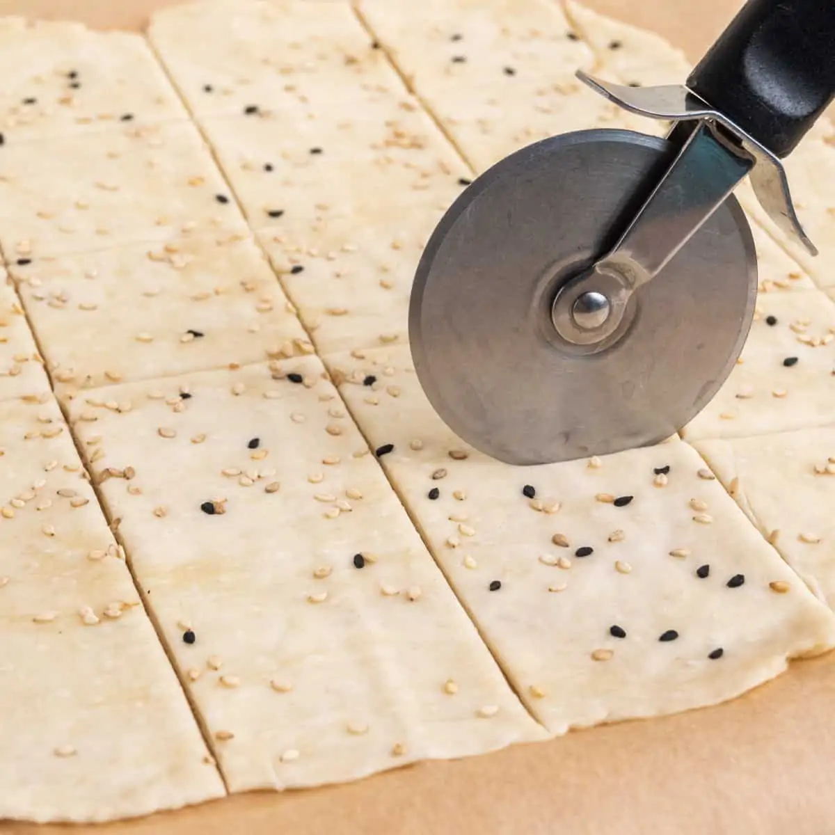 Cutting crackers into squares with a pizza roller.