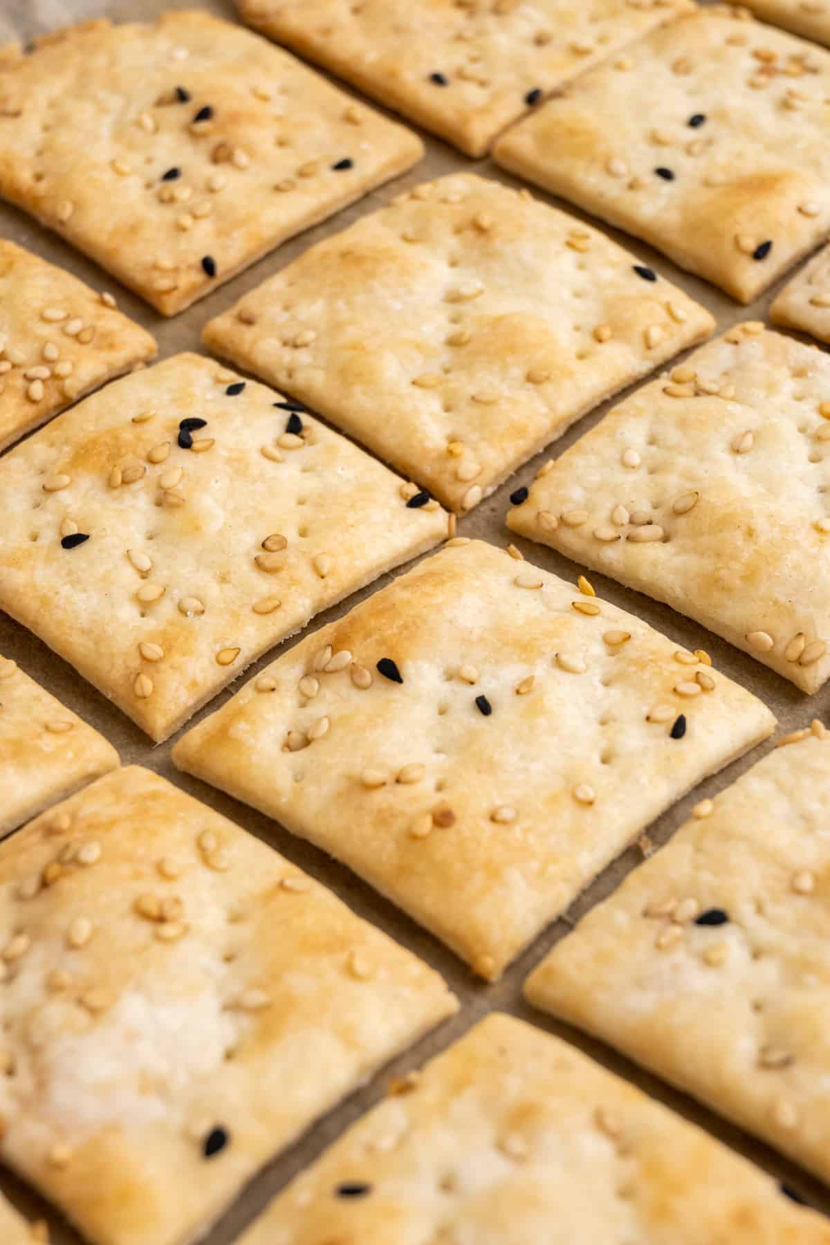 Diamond shaped sourdough crackers on a baking tray.