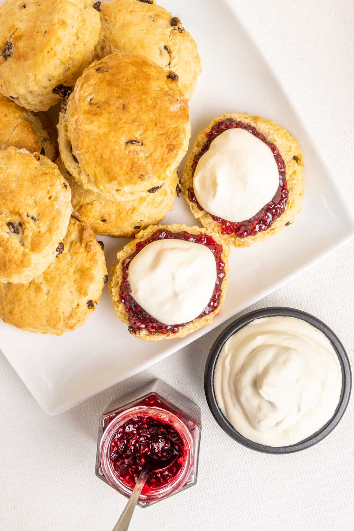 A completely vegan serving of scones, raspberry jam and whipped cream.