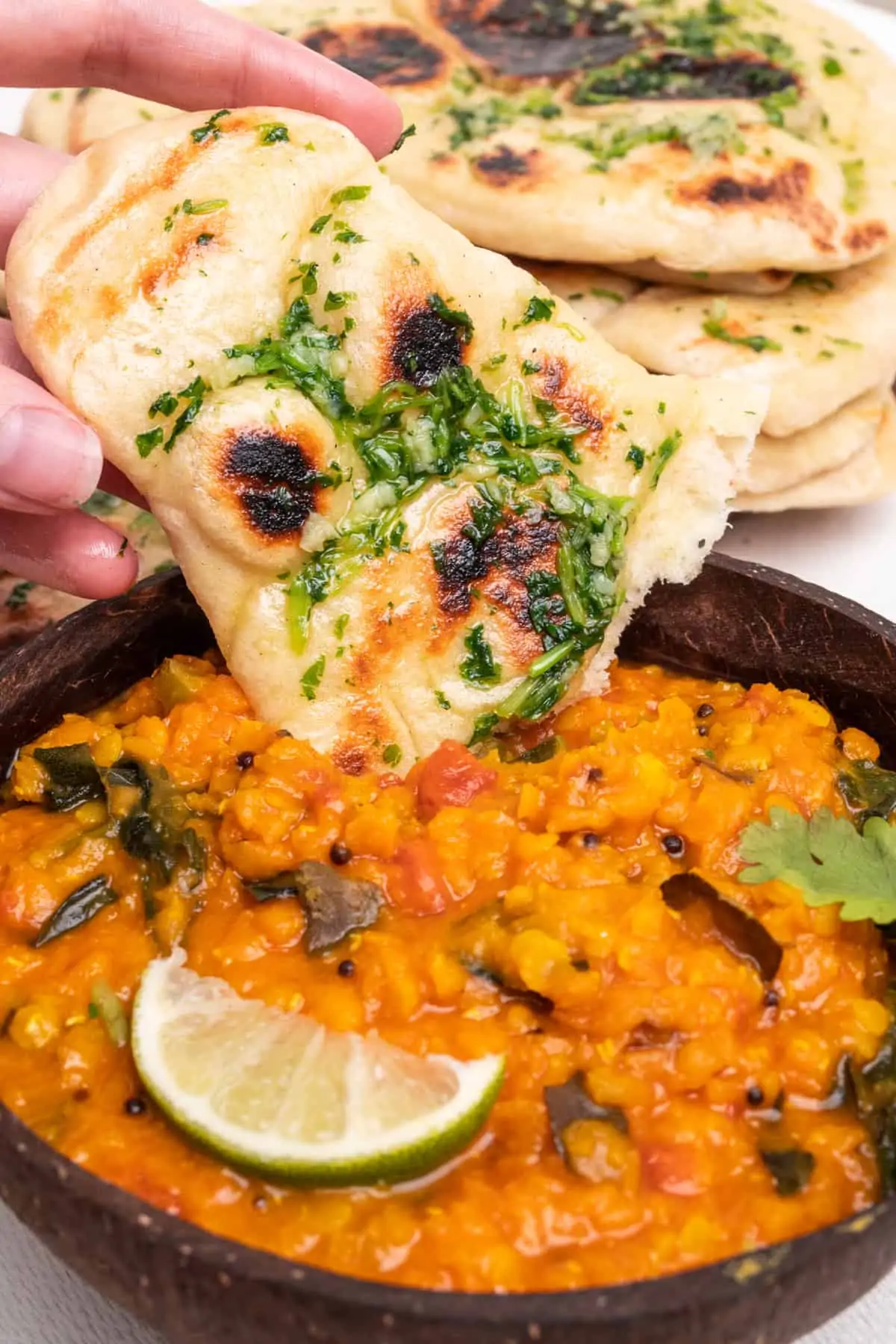 Garlic and coriander naan bread dipped into a red lentil curry. A perfect combination!