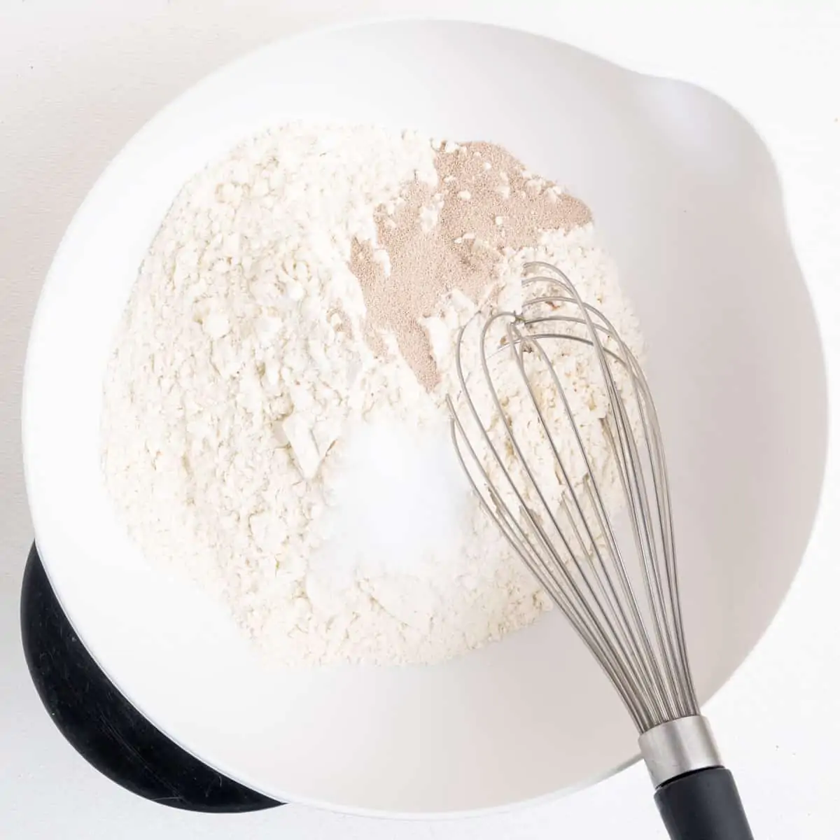 Flour, dried yeast, salt and sugar whisked together in a mixing bowl.