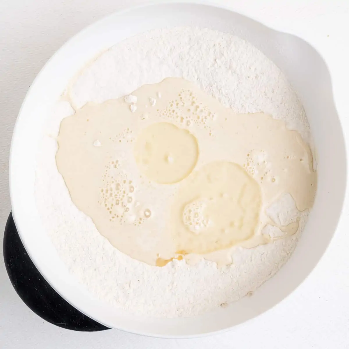To the dry ingredients in the mixing bowl, soy milk, oil and lemon juice are added.