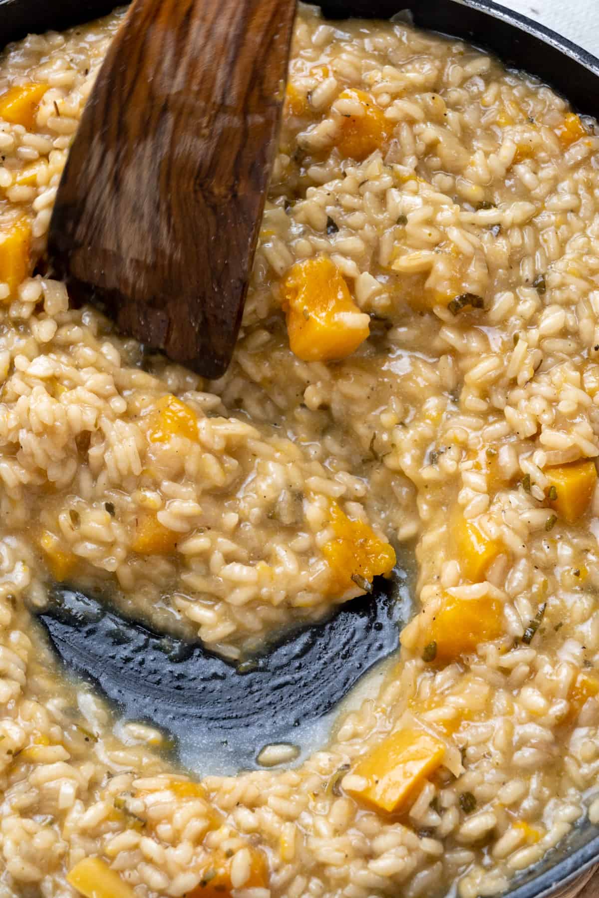 A spatula stirs the finished risotto, showing the creamy texture.
