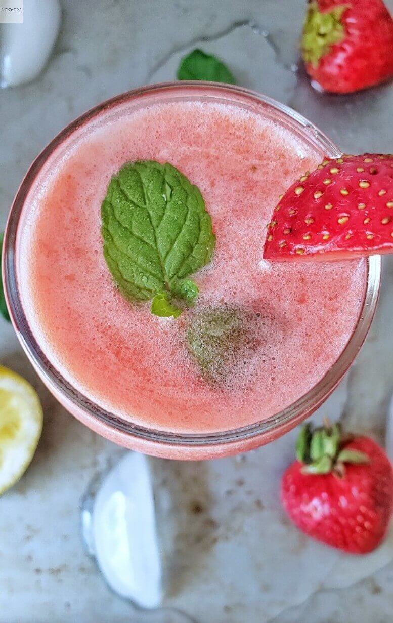 A glass of strawberry lemonade garnished with mint.
