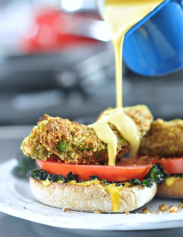 Pouring hollandaise sauce on an Avocado Kale Florentine.