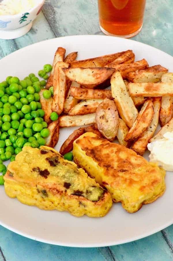 A plate of vegan fish and chips with peas.