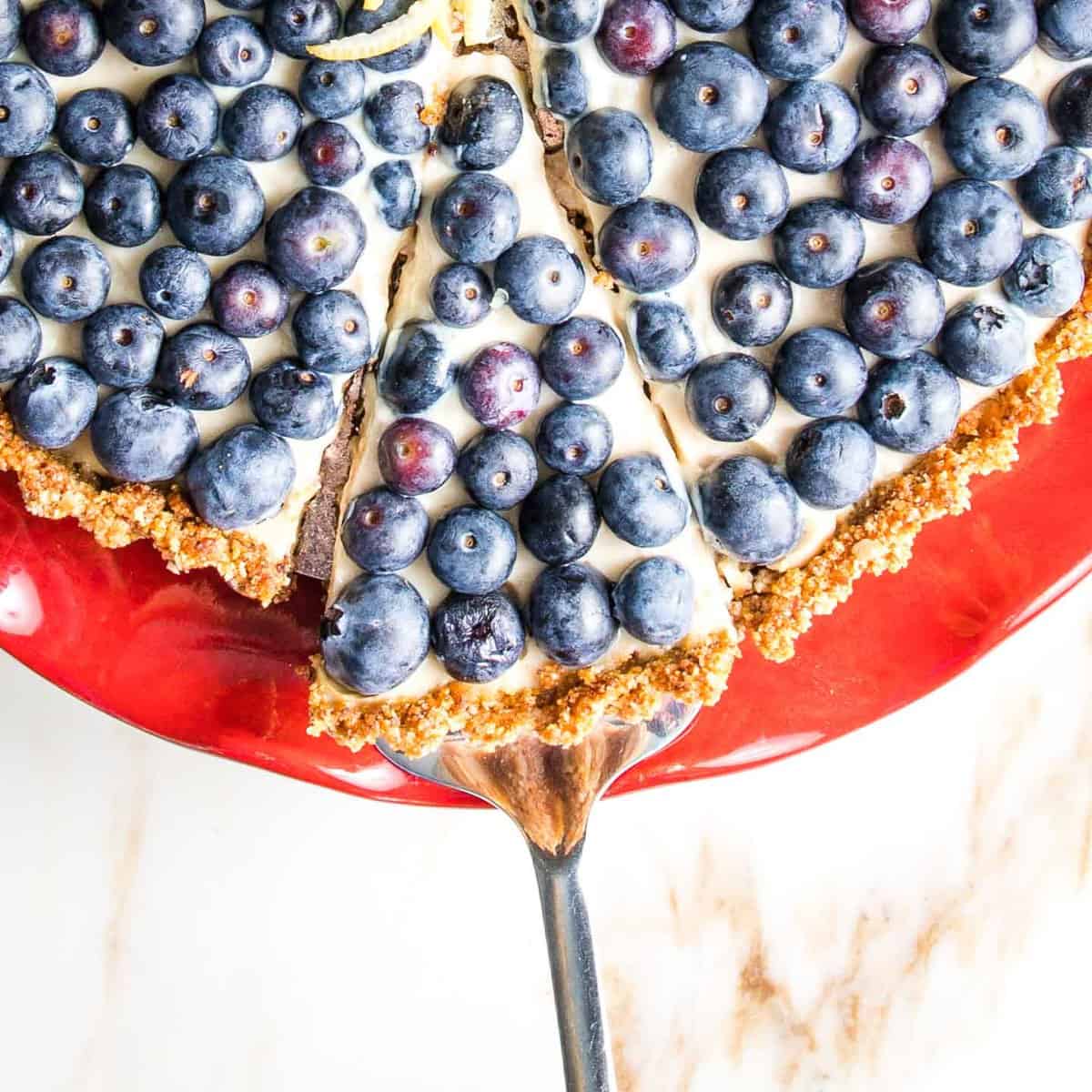 Lifting a slice from a vegan blueberry tart.