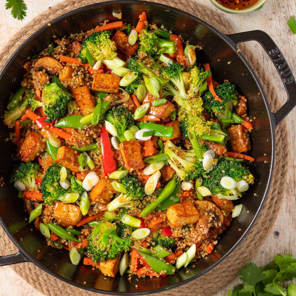 A pan of tofu and quinoa stir fry with veggies.