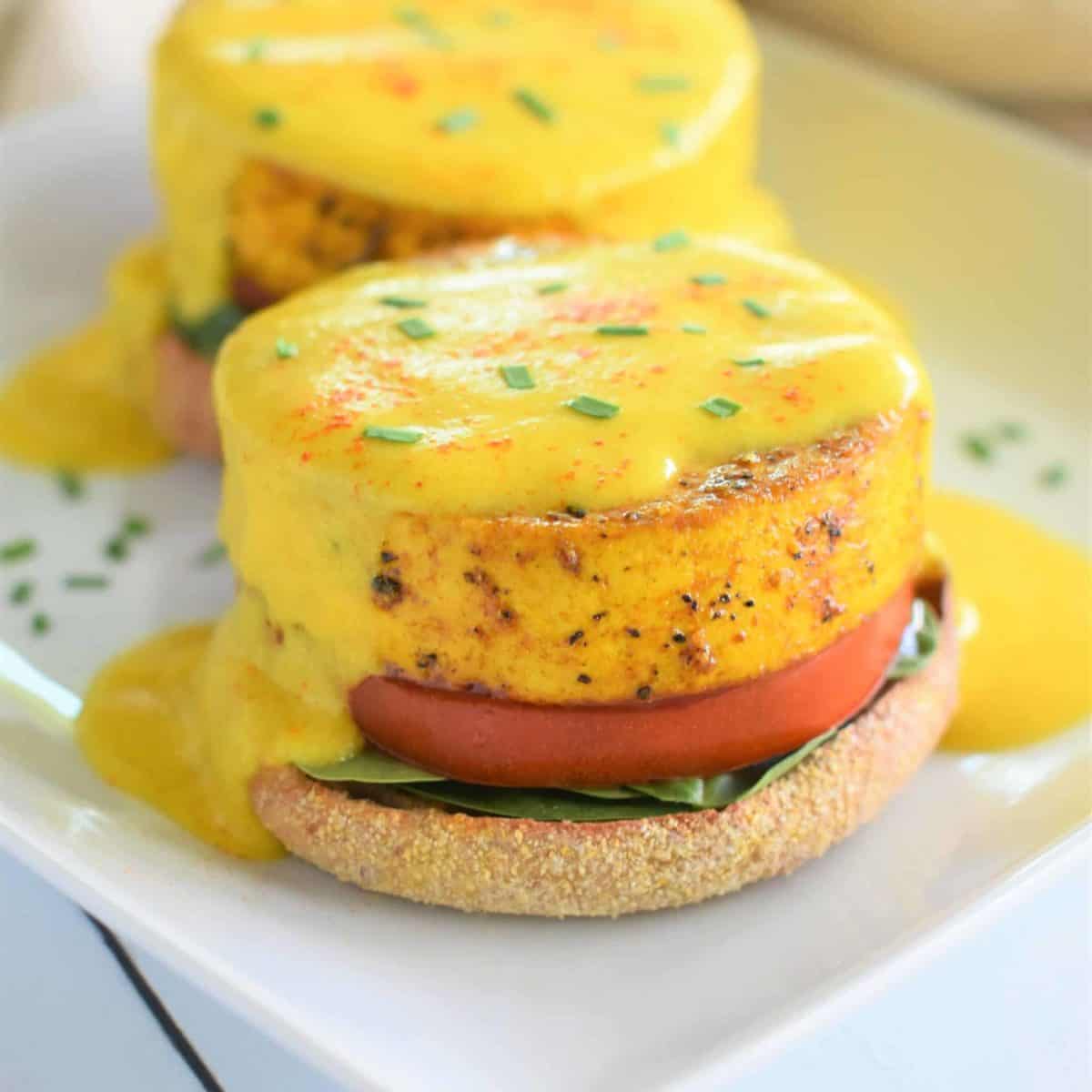 A tofu pattie on a bun topped with egan hollandaise sauce.