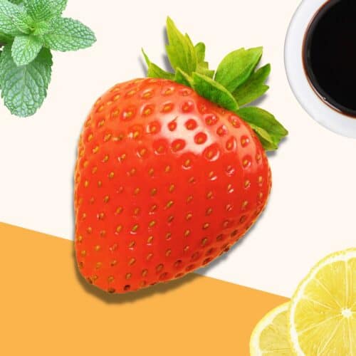 A strawberry on an orange and cream backdrop, surrounded by other ingredients - lemon, mint and balsamic vinegar..