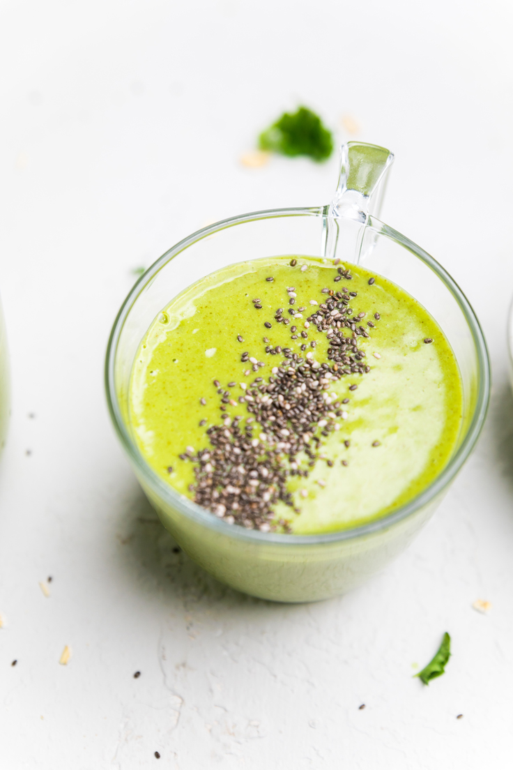 A glass with kale smoothie topped with chia seeds. 