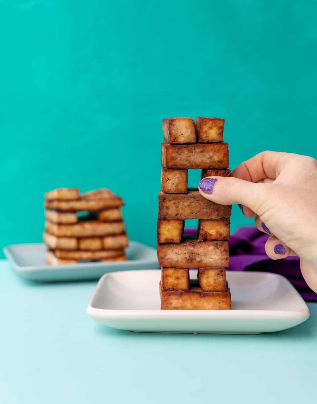 Tofu pieces stacked in a jenga like tower.