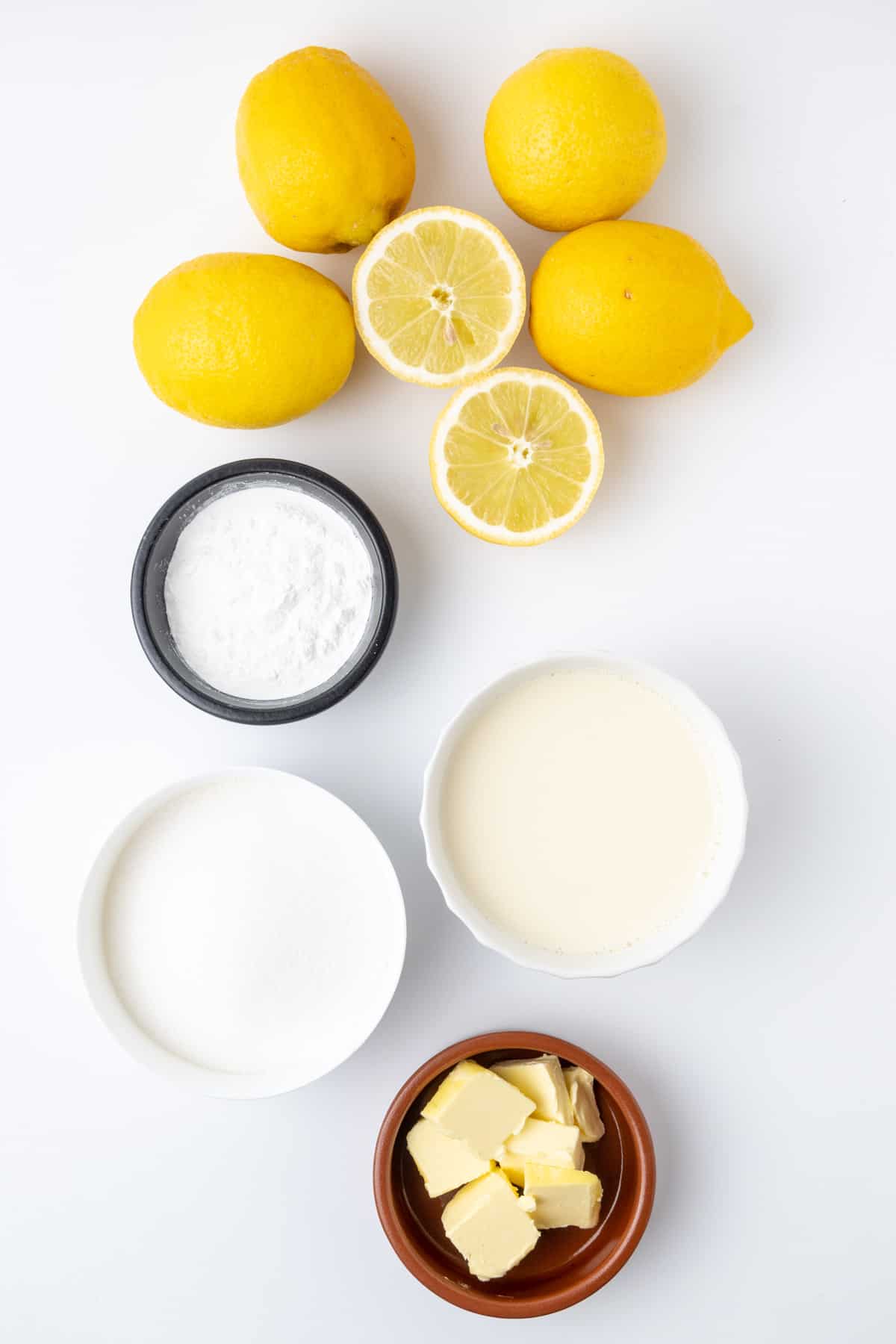Όλα τα υλικά για το vegan lemon curd απλώνονται σε λευκή επιφάνεια.