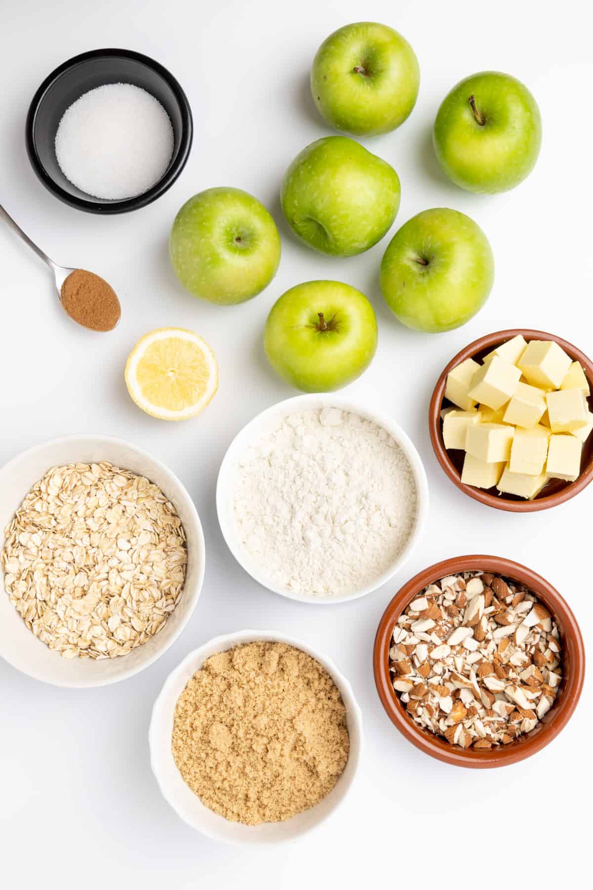 Ingredients for vegan apple crisp on a white surface.