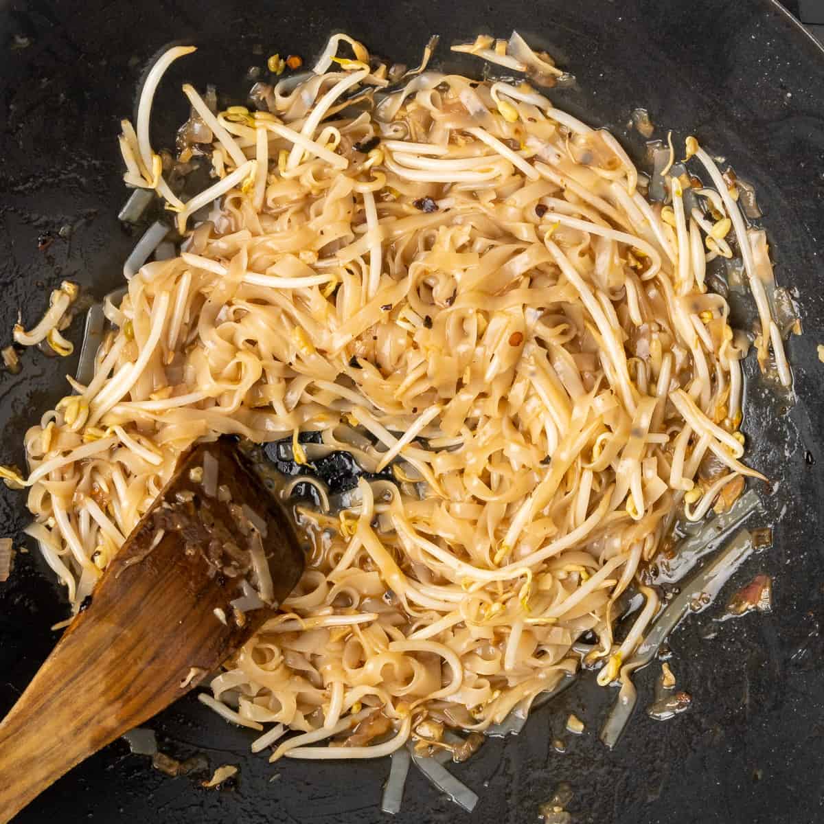 Rice noodles, beansprouts and pad thai sauce being stir-fried.