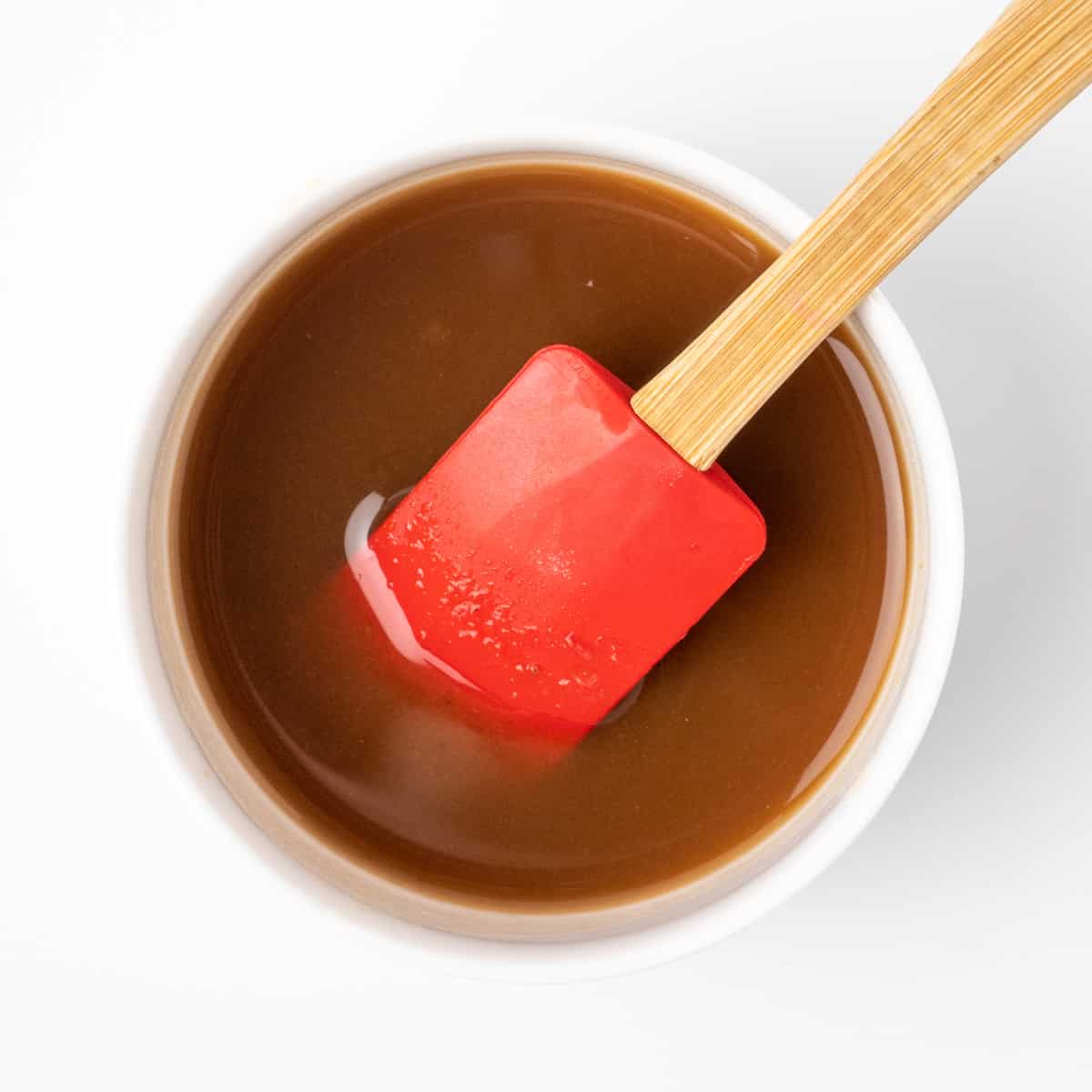 Mixing tamarind, vegan fish sauce, and water into pad tahi sauce.