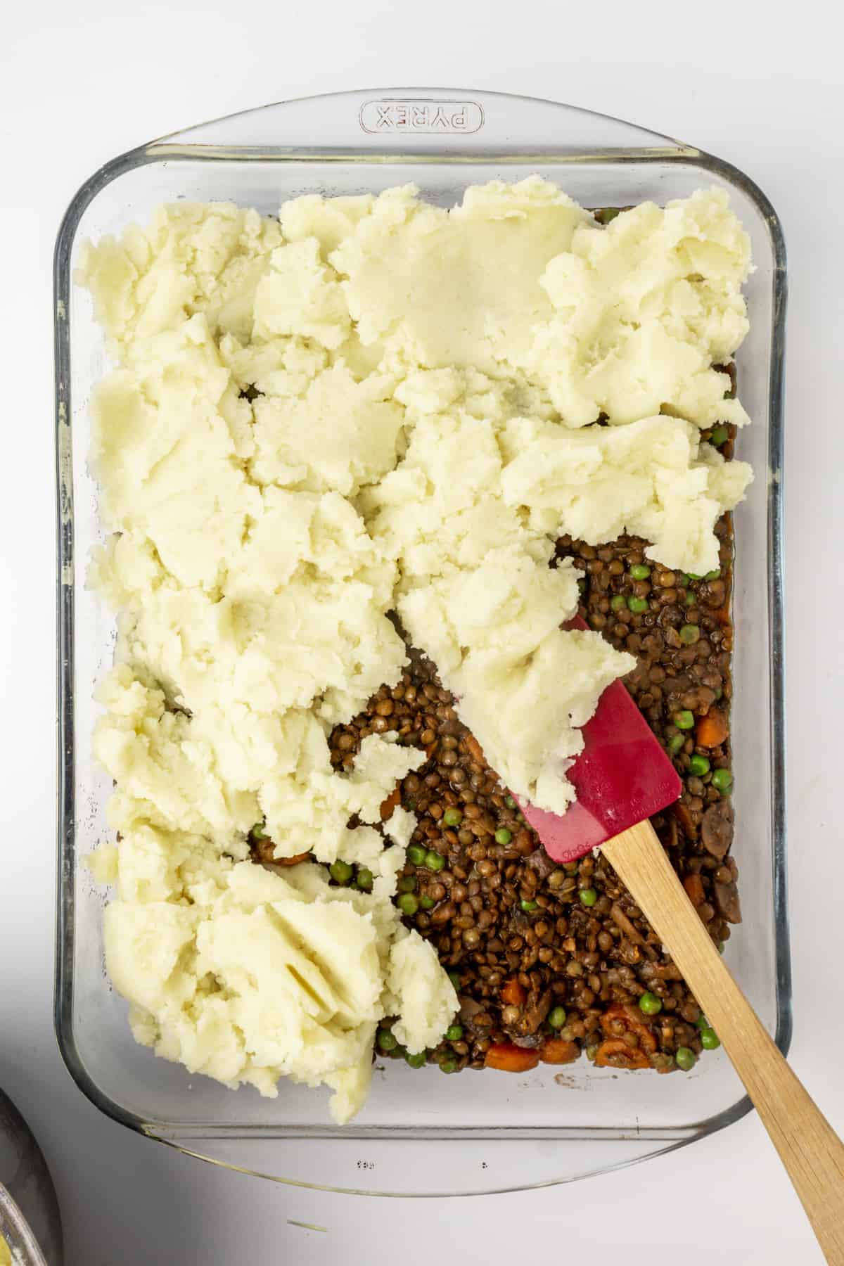 Lentil and vegetable filling topped with mashed potato in a baking dish.