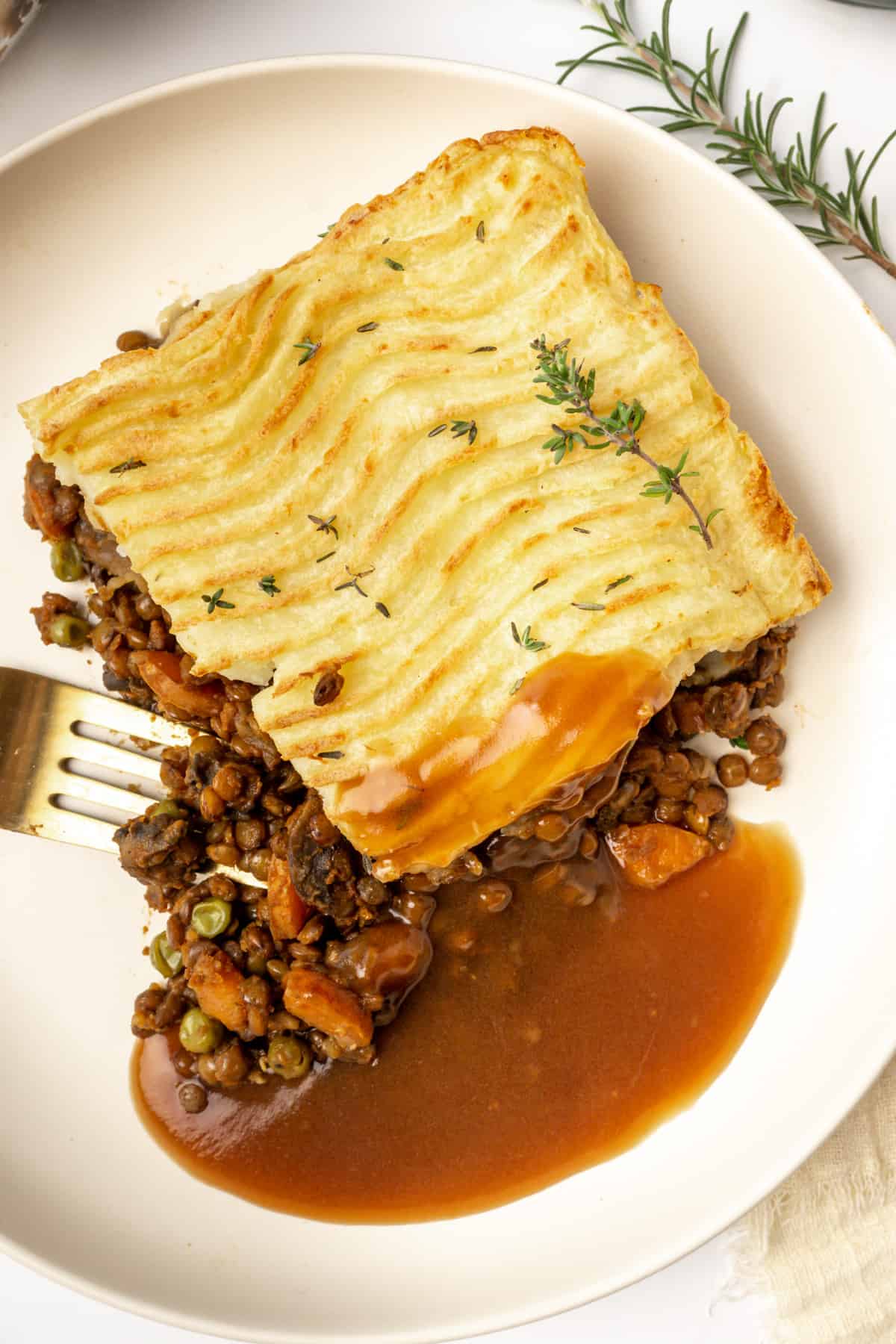 Lentil shepherds pie with gavy on a plate.