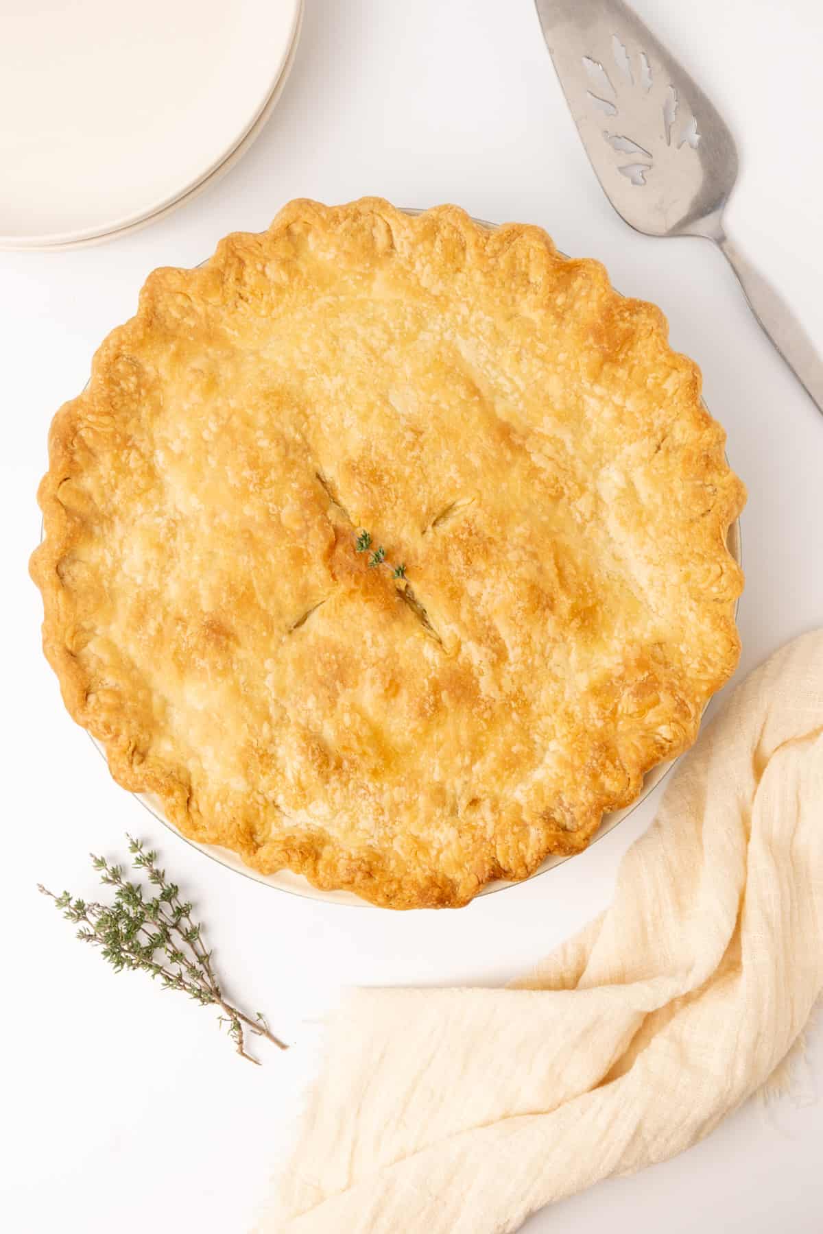 A golden baked pie on a table ready for serving.