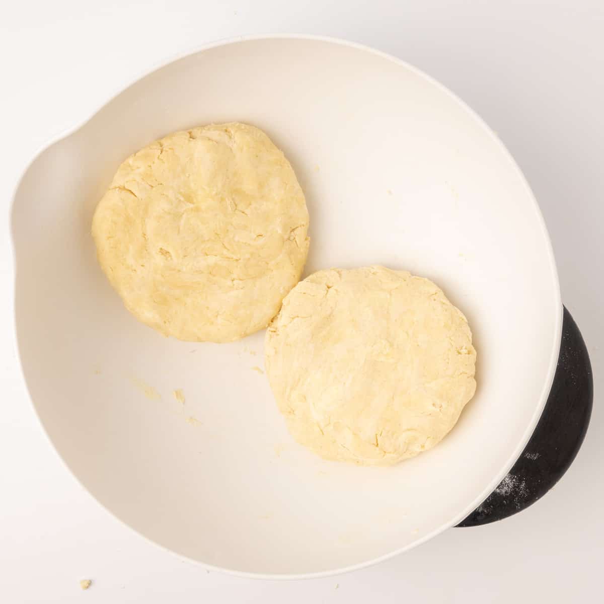 Two slightly flat rounds of pastry dough in a mixing bowl.