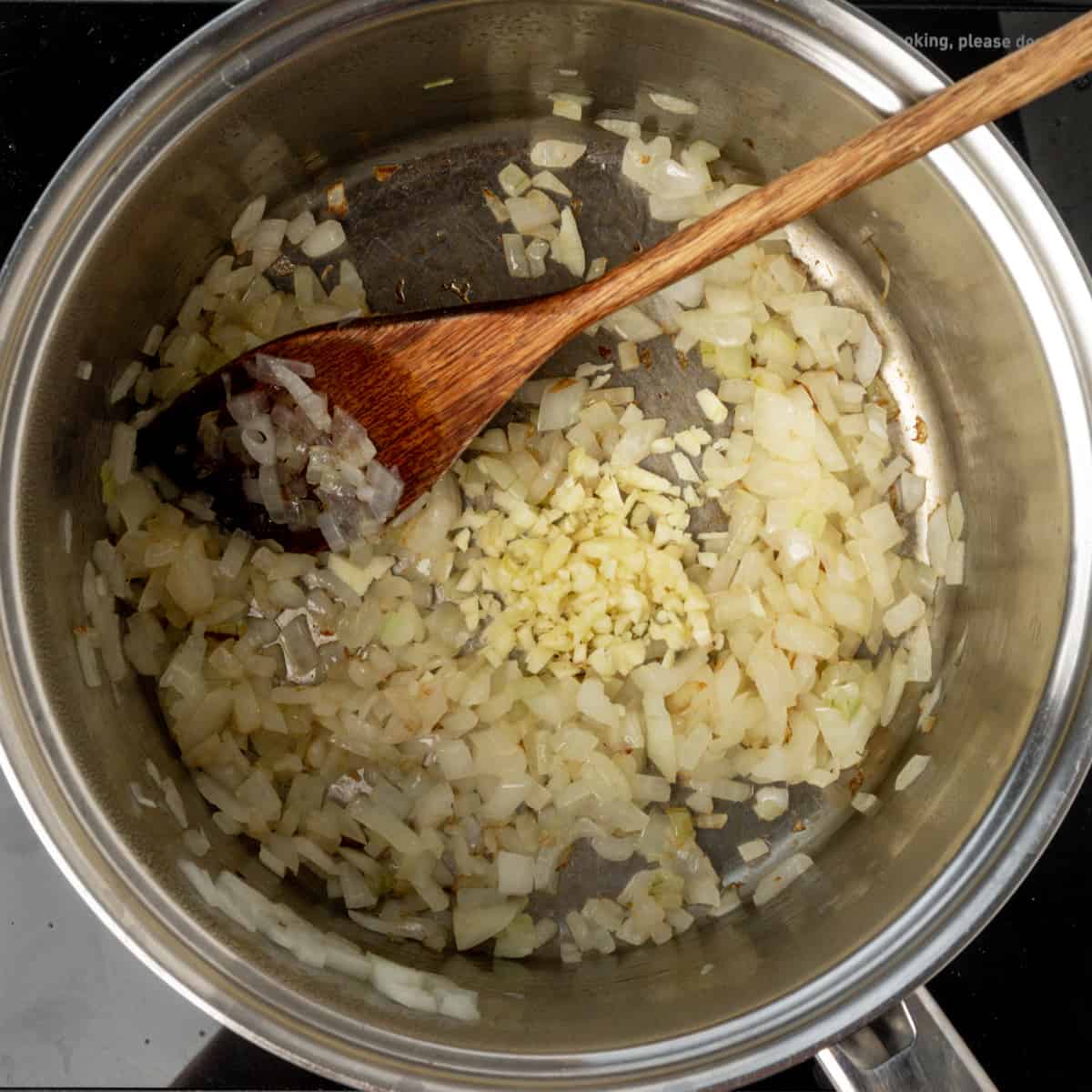 Minced garlic and diced onions in a saucepan.