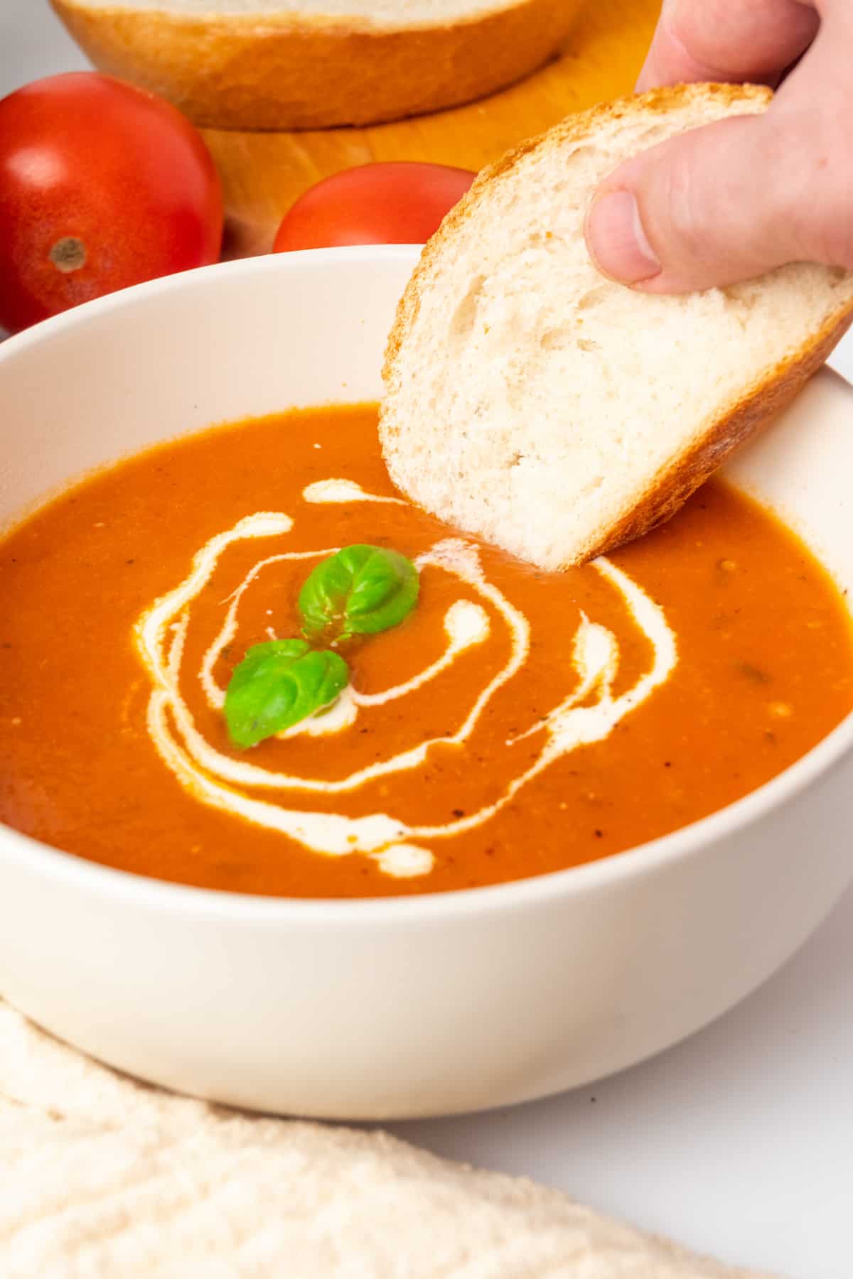 Dipping a slice of white bread into tomato soup.
