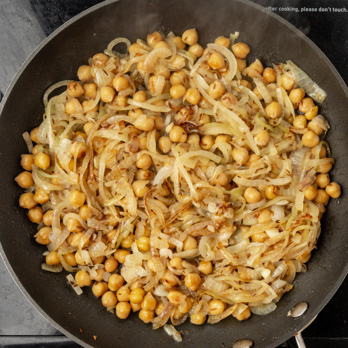 Onion and chickpeas in a skillet.