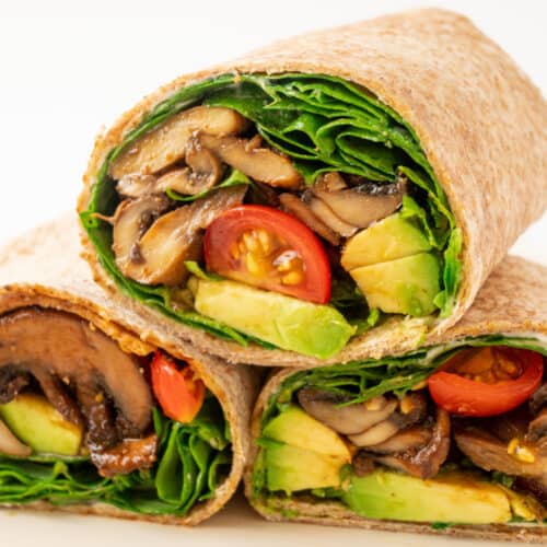 A stack of three mushroom, spinach, tomato and avocado wraps.